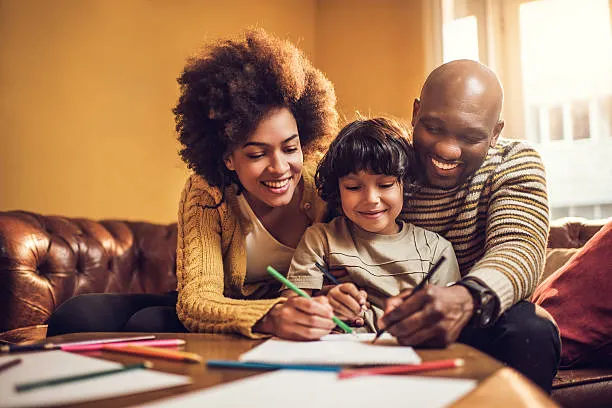 Joyful mother and father coloring with their child using FreeColoringNCH printable sheets, enjoying creative family time at home